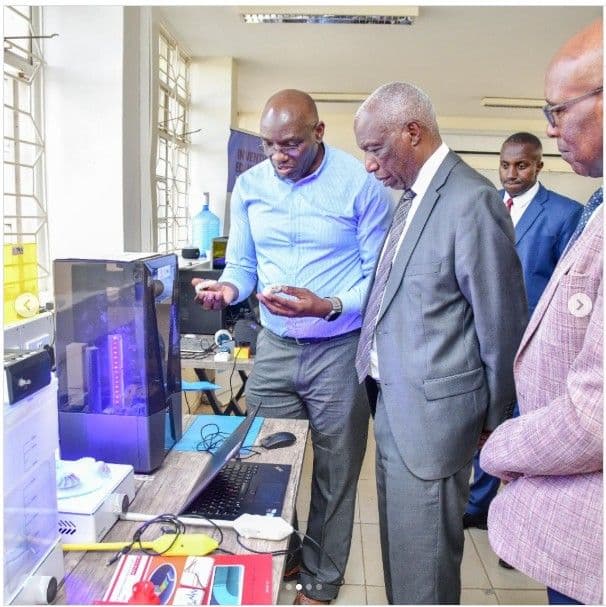 Faculty member showing a resin 3D printer to visiting guests