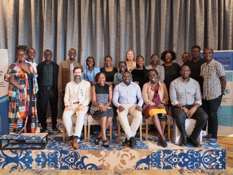 Stakeholder engagement guests in a group photo between Invention Education banners