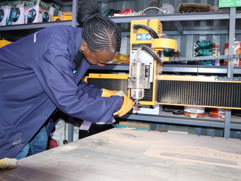 Participant in gloves setting up a CNC machine
