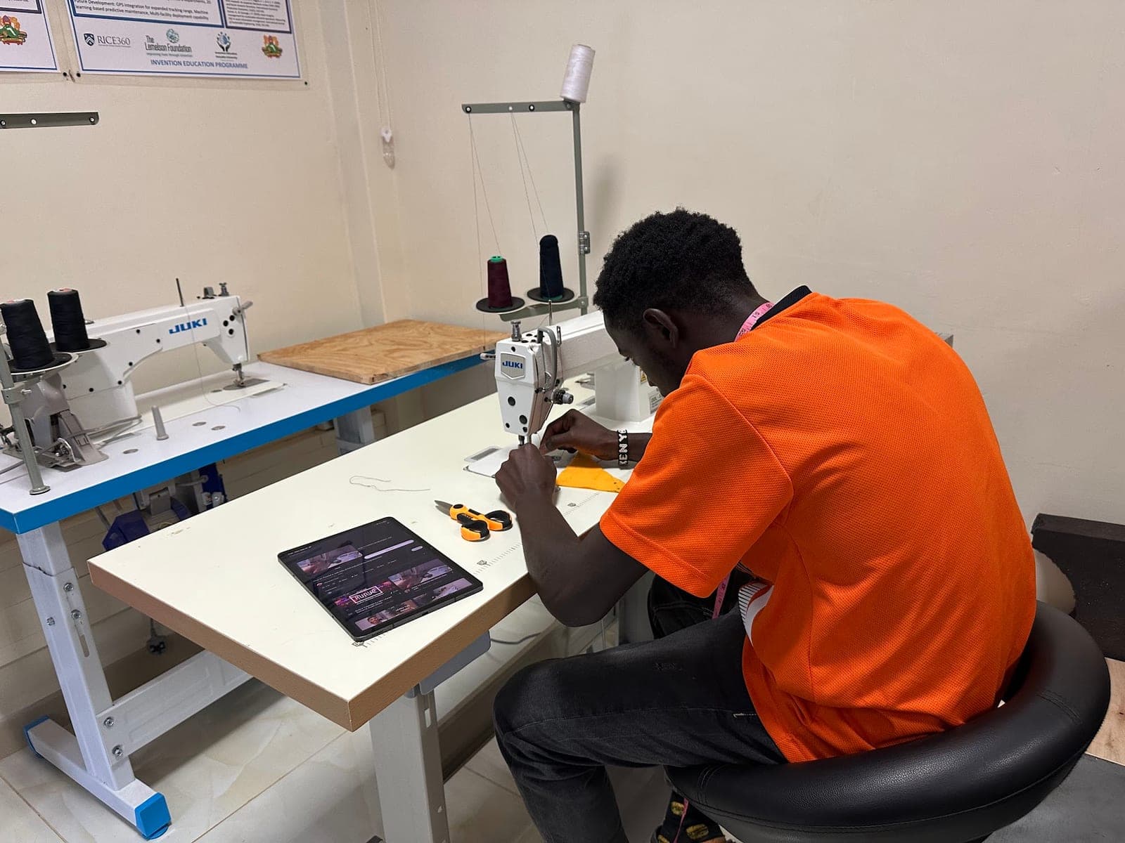 Student working at an industrial sewing machine in the textiles area