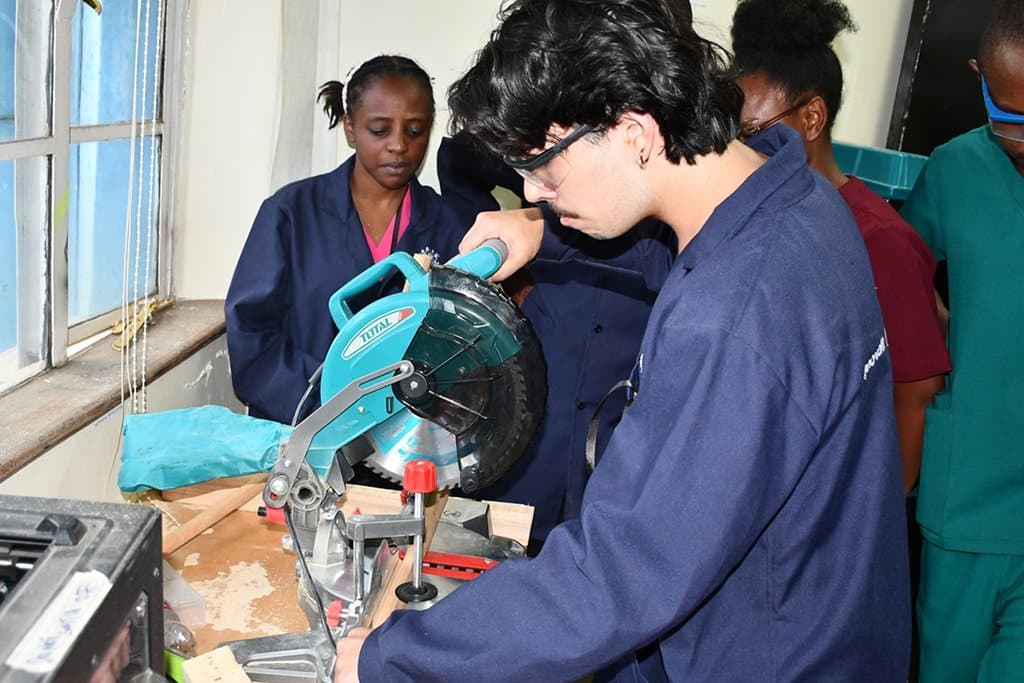 Student cutting timber on a mitre saw