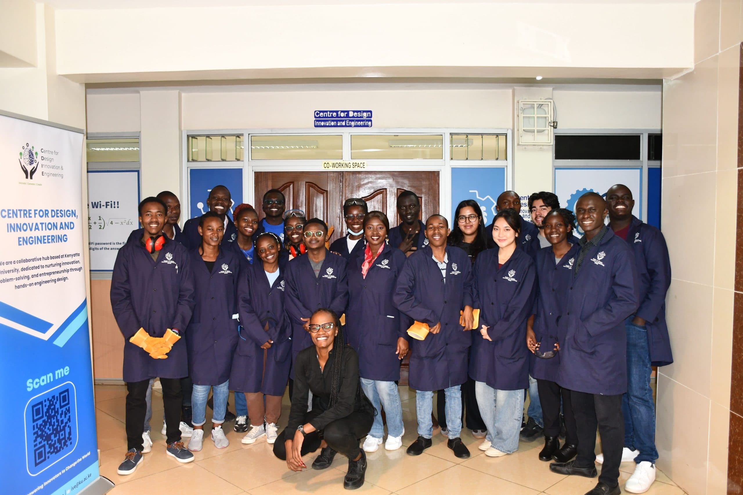 Students in navy lab coats standing together in front of the CDIE entrance