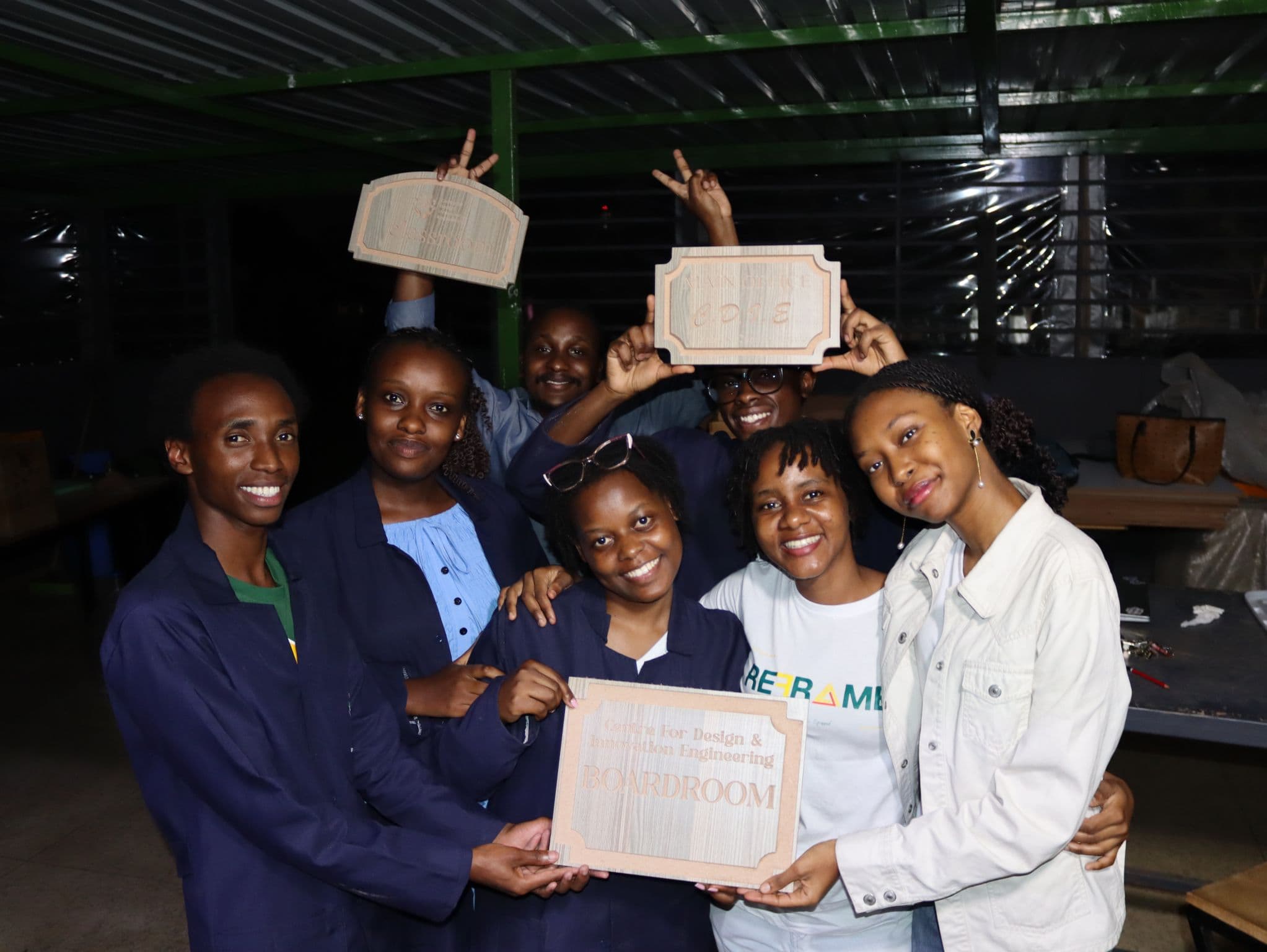 Participants holding laser-engraved wooden signs for the CDIE boardroom, classroom and main office