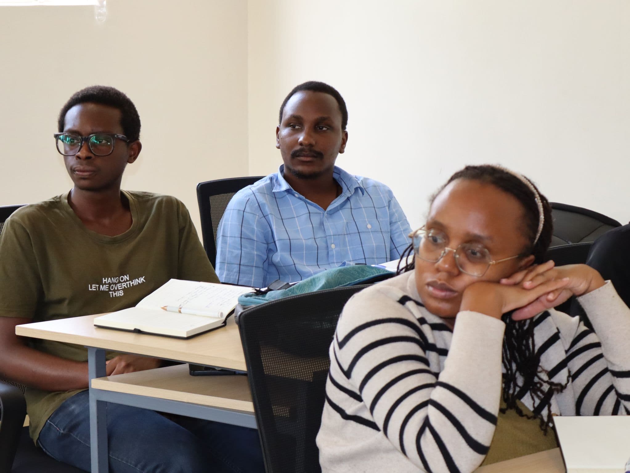 Participants listening in class with notebooks open